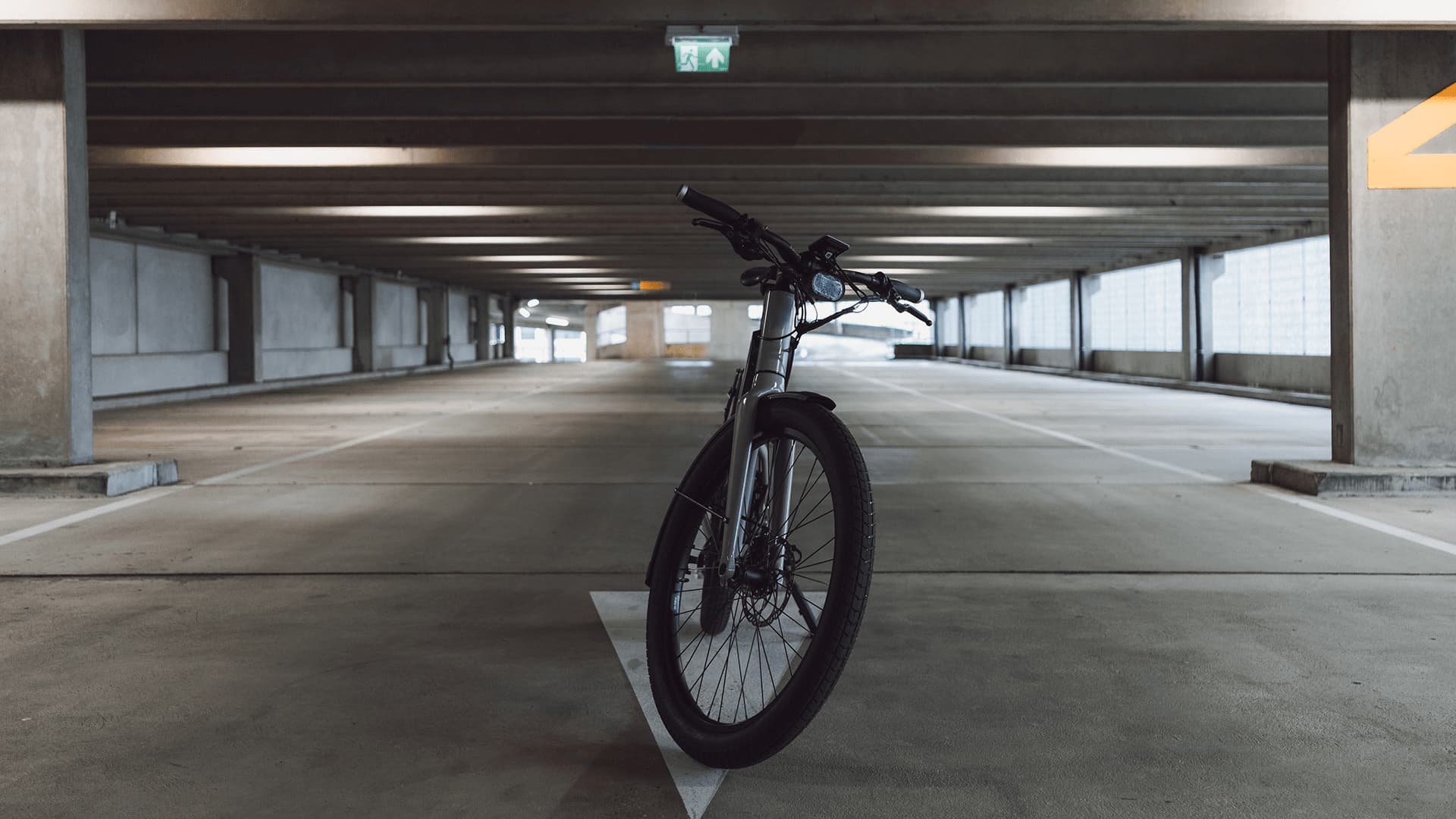 Byqr's product photography from the site's carousel: the bike standing alone in an empty parking garage.