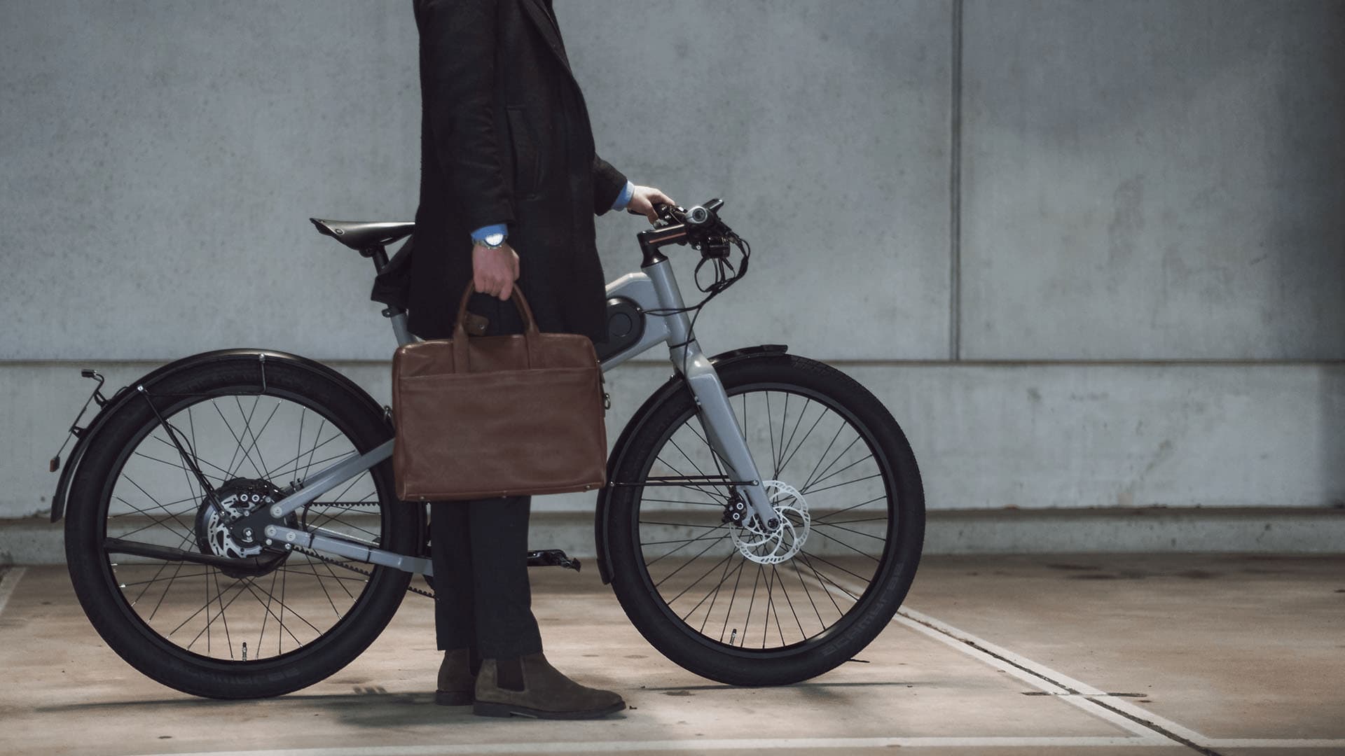 The Byqr from the side, with the commuter standing next to it.