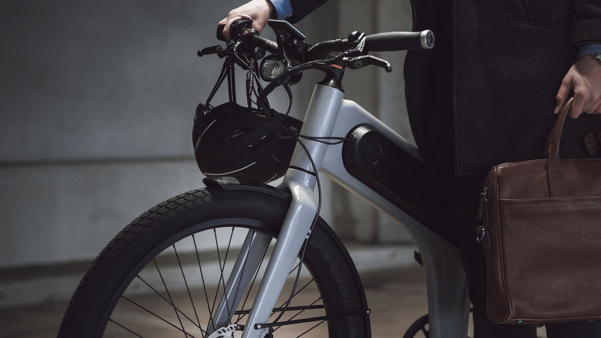 The front of the bike with a helmet hanging from the handlebar, ready for the ride to work.